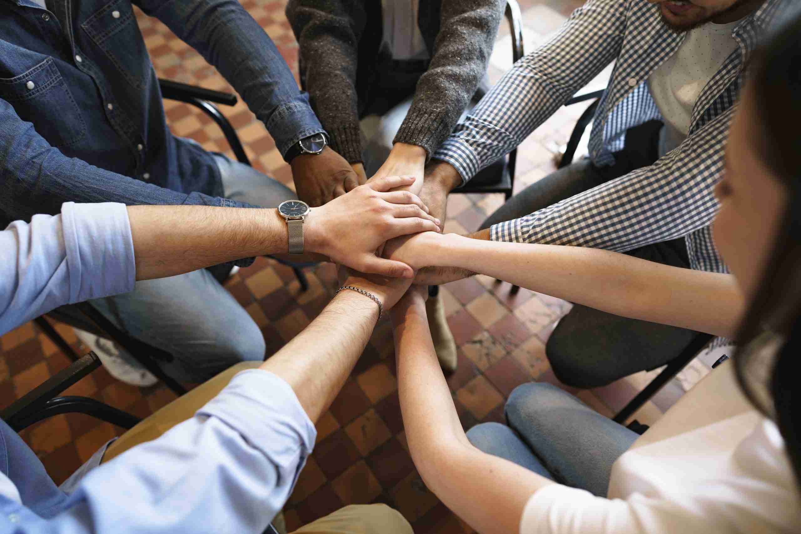 Top view of diverse people hands holding together in circle, hands stack